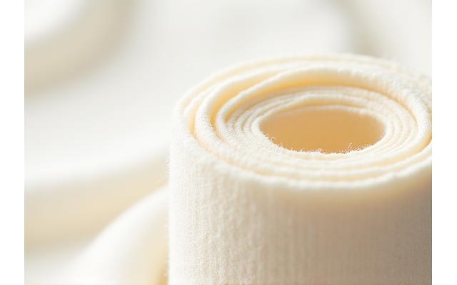 Gros plan sur un rouleau de coton biologique texturé de couleur naturelle.